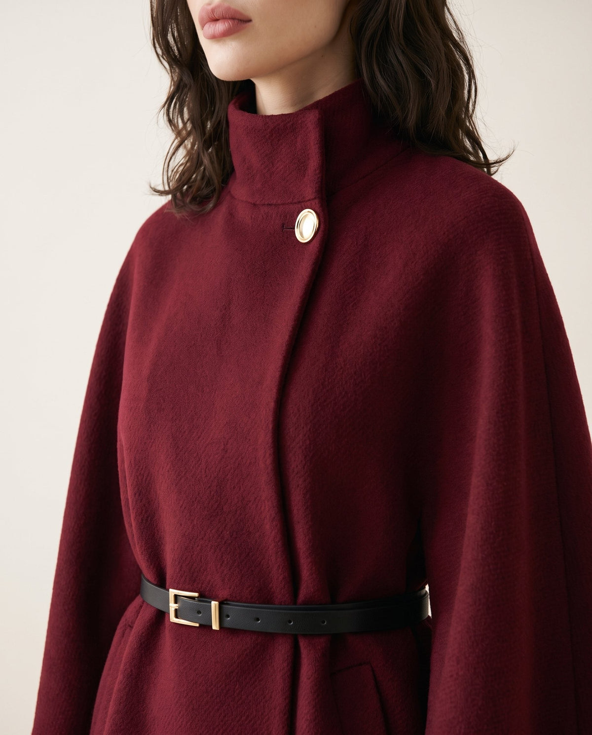 ELARA belted cape in wine red, detail of the funnel collar, gold-tone button and belt